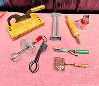 All antique kitchen tools arranged on pink fabric