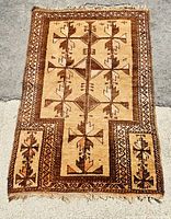 Top-down view of the entire antique Persian carpet showing geometric design in brown shades.