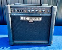 Front view of Behringer V-TONE GM108 guitar amplifier showing control panel with input jack, analog modeling, drive knob, CD input, EQ knobs (low, mid, high), headphone jack, master volume knob, power switch, and Behringer logo on speaker grille.