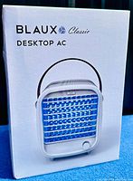 Front side of the BLAUX Classic Desktop AC portable cooling fan retail box showing the product image and branding.
