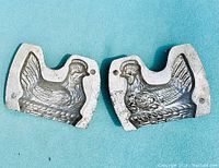 Two mold halves viewed from above, showing detailed hen shapes and pointers for alignment.