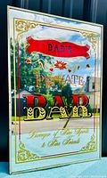 Front view of vintage mirror sign with decorative gold and red lettering 'Dad's Private Bar'. Reflects outdoor background.