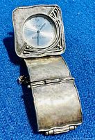 Side angle of vintage Silpada sterling silver bracelet watch showing hammered texture and unique square watch face with waved edges.