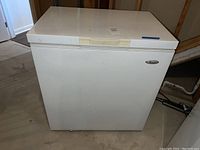 Front view of white Whirlpool chest freezer showing brand logo and overall condition.