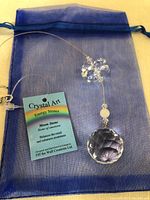 Crystal Art suncatcher with faceted crystal ball and moonstone, displayed on blue pouch with informational tag.