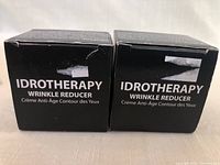 Front view of 2 black boxes labeled Idrotherapy Wrinkle Reducer eye cream.