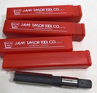 Three red plastic cases labeled J.A.M. Taylor Tool Co. and one tap with visible oxidation in front.