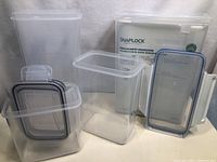 Four SnapLock food storage containers, including a set of three containers and one separate container. All containers are clear plastic with snap-lock lids and blue sealing gaskets.