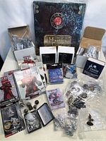 Photo showing the full assortment of miniatures, including boxed sets, loose miniatures, dice, and a large themed binder.