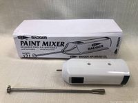 White Badger battery operated paint mixer with metal mixing rod and original box.