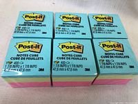 Top view of six Post-it Note cubes with packaging showing product and size details.