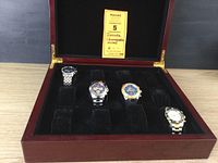 Four Invicta chronograph watches arranged in a wood display case with six slots