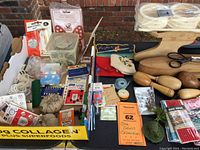 Wide view of sewing collection showing wooden tailoring tools, sewing notions, trims, pins, buttons, and containers with assorted supplies