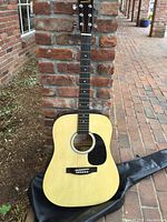 Full front view of Starcaster by Fender acoustic guitar showing natural finish body with black pickguard and six strings.