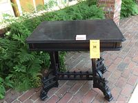 Front and top view of the Victorian ebonized table showing square top, sturdy architectural base with casters, and overall dark finish.
