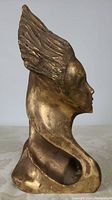 Right profile view of bronze bust showing hair and facial contour