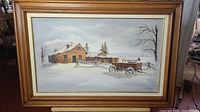 Full view of the framed winter landscape painting showing a rustic country house, snow, and a cart.