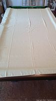 Large cream or off-white rectangular tablecloth spread on a surface