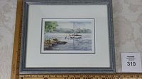 Framed watercolour artwork with a sailboat on calm water and surrounding natural elements.
