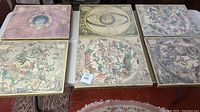 Six Masonite mounted art paper prints with vintage celestial and zodiac themes arranged on table