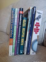 Photo showing 8 DIY books standing upright on a couch, titles clearly visible