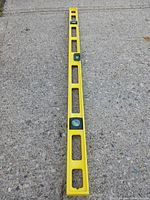 Top view of the level showing three bubble vials and open rectangular cutouts in the yellow plastic frame