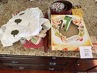 Overview of all items including chef's jacket, tins, ceramic shortbread pan box, rolling pin, kitchen linens, and cutting boards spread on a countertop.