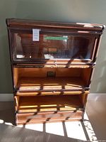 Overall front view of three-shelf oak barrister bookcase with glass-front doors