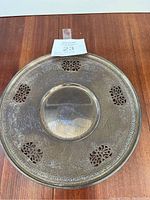 Top-down view of entire round platter showing pierced cutouts and decorative engraved border