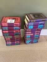 Stack of hardcover books showing various spines and colorful dust jackets with Oxford branding and author/title text