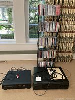 Kenwood stereo receiver and MTC CD player side by side in front of CD rack