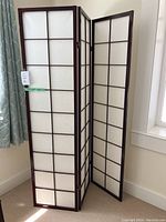 Full view of three-panel folding screen standing upright, partially folded. Screens have wooden dark brown frames with translucent paper inserts.