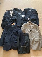 Overview of four suit jackets laid out on floor