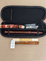 Two Johannes Adler wooden recorders shown, one in black padded case with cleaning accessories and one in original cardboard box with paperwork.