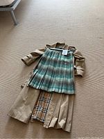 Coat and skirt laid flat on floor