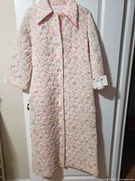 Front view of vintage quilted duster house coat showing button-up front, collar, and long sleeves.