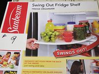 Box front showing the Sunbeam Swing Out Fridge Shelf with image of shelf loaded with various foods including grapes and condiments.