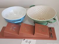 Lot showing two vintage enamel colanders and a mid-century modern style plastic letter/memo holder.