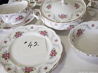 Covered casserole with lid (center), gravy boat with underplate (left) and dinner plate (foreground)