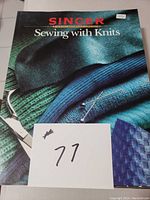 Front cover of the 'Sewing with Knits' book showing a teal and green fabric background and sewing pins.