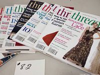 Fifteen Threads sewing magazines stacked showing colorful covers with sewing related headlines and images.