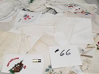 Lot of white vintage handkerchiefs spread out showing embroidery and lace features.