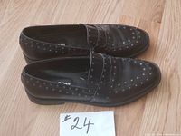 Pair of black Napoleoni studded leather loafers with size and brand visible.