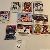 Multiple stacks of Tim Hortons hockey card inserts featuring various NHL players laid out on a white surface.