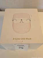 Photo of the box showing the product name '3 Color LED Mask' and a sketch of the mask on front.