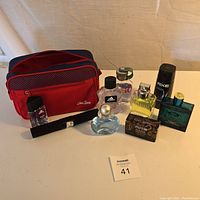 Photo of nine men's grooming items including colognes, body spray, soap, and a travel bag on white surface.