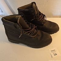 Side view of both brown Dexter boots showcasing their shape, leather texture, and lining.