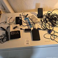 Photo showing multiple electronic accessories including charging cables, earbuds, power banks, and battery packet