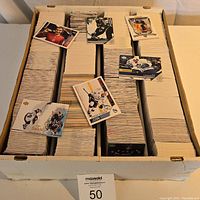 Top view showing rows of hockey cards in a large storage box with some cards facing up including Joe Sakic, Mats Sundin, and others.
