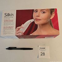 Box with image of woman using Silk'n Intelligent Diamond Microdermabrasion device and text describing product features.